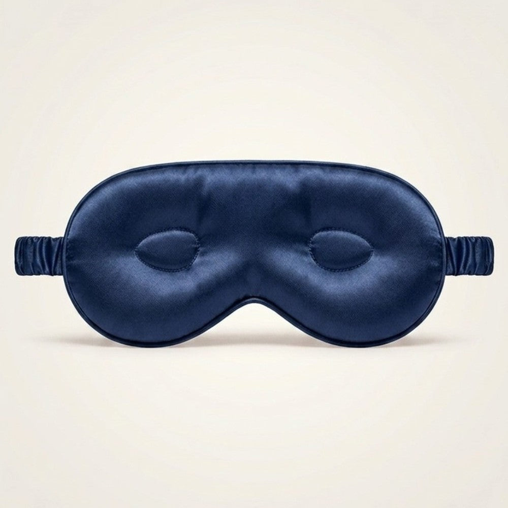 Navy blue silk sleep mask on a beige background