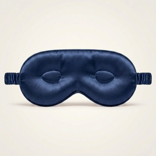 Navy blue silk sleep mask on a beige background