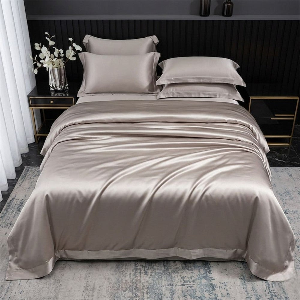 Beige silk bedding set on a bed in a bedroom setting.