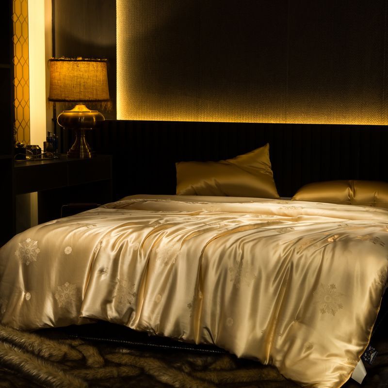 Luxurious bedroom with a bed covered in a gold yellow silk duvet cover.