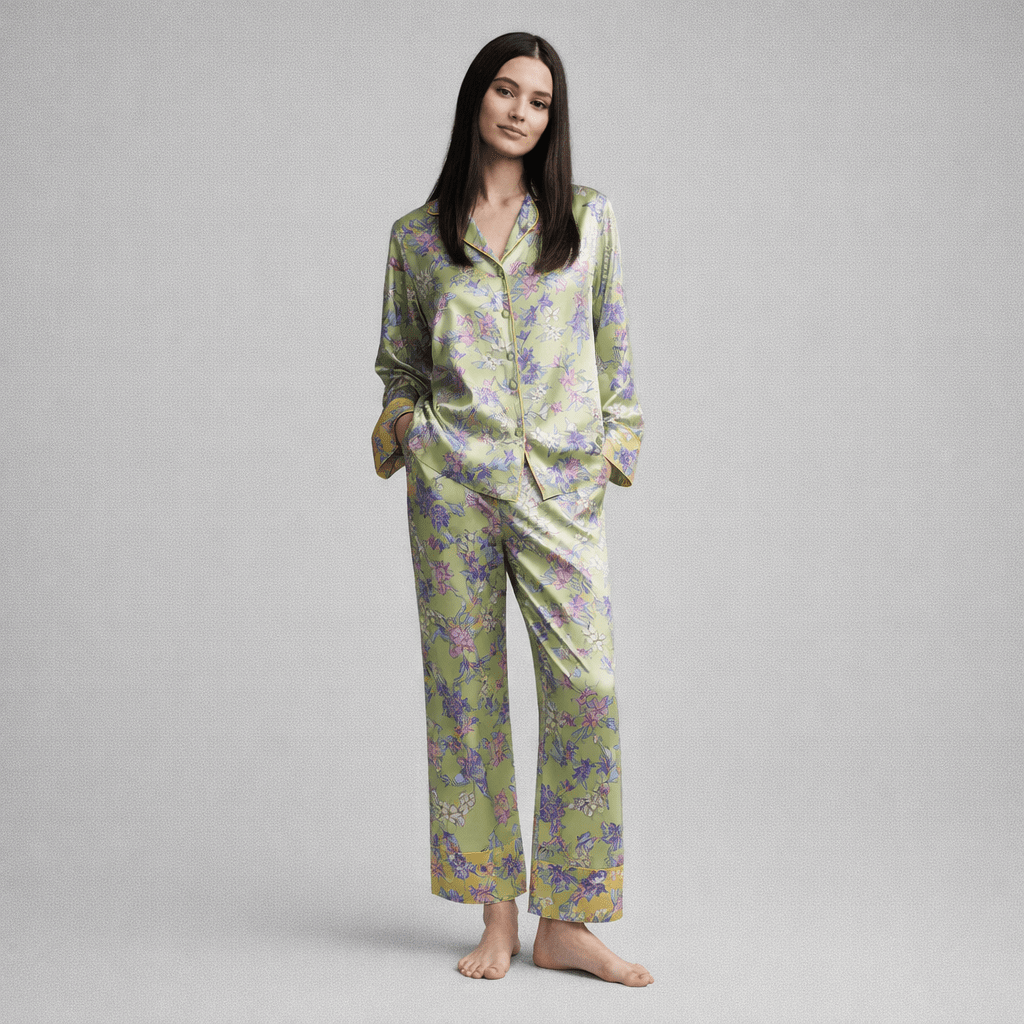 Woman wearing a green floral silk pajama set on a gray background