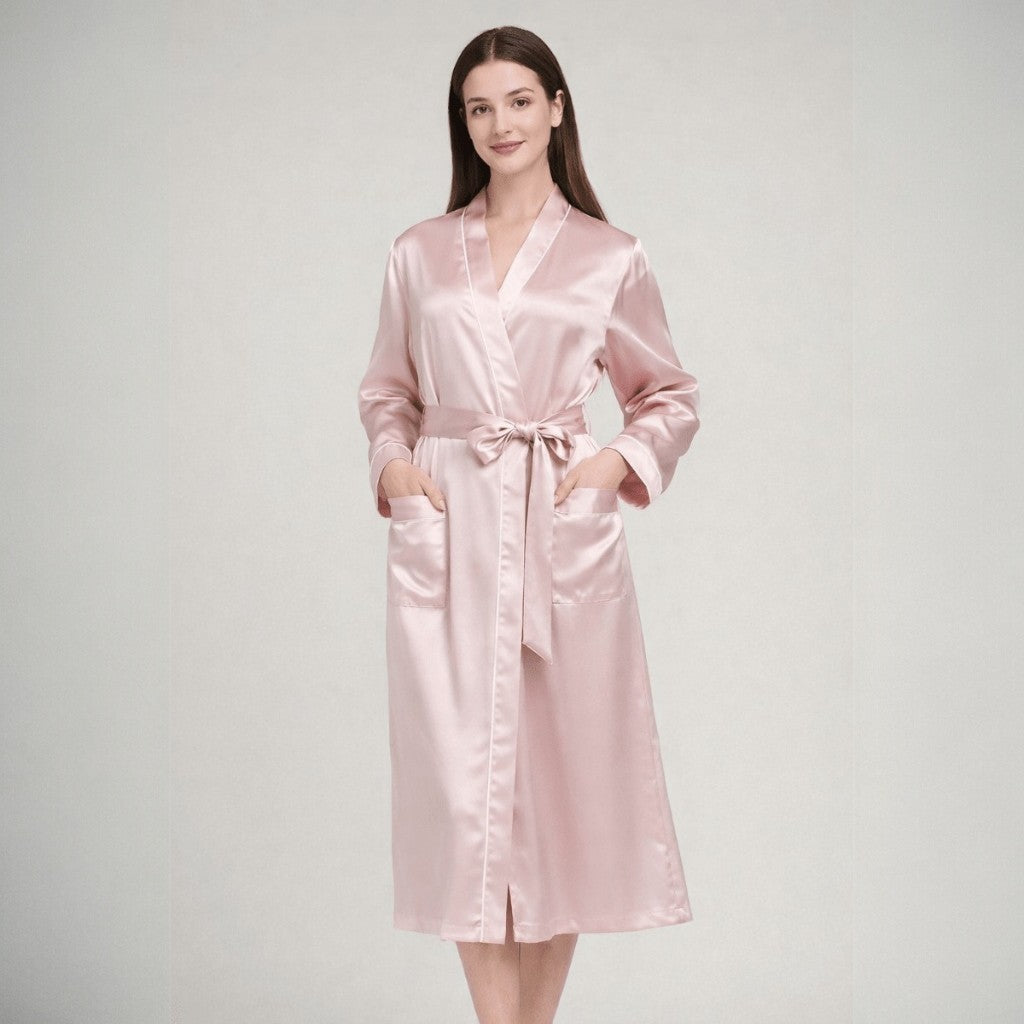 Woman wearing a pink silk robe on a plain background