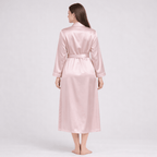Woman wearing a pink silk robe on a white background