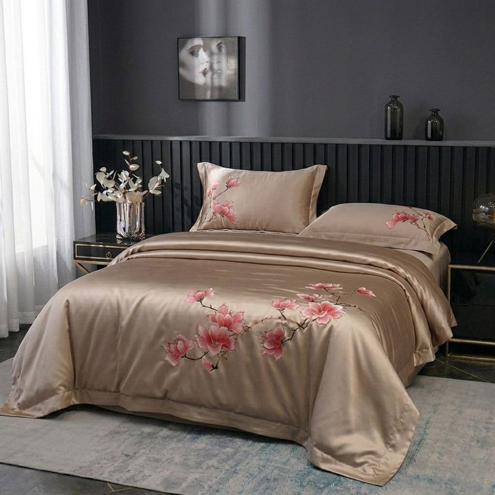 Beige bedspread with floral embroidery on a bed in a bedroom setting.