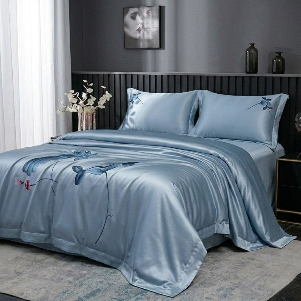 Blue floral bedspread set on a bed in a bedroom with decorative elements.