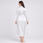 Woman wearing a white silk robe on a plain background