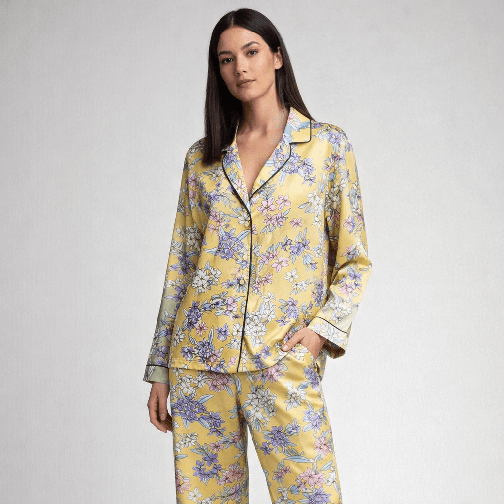 Woman wearing a yellow floral pajama set on a gray background